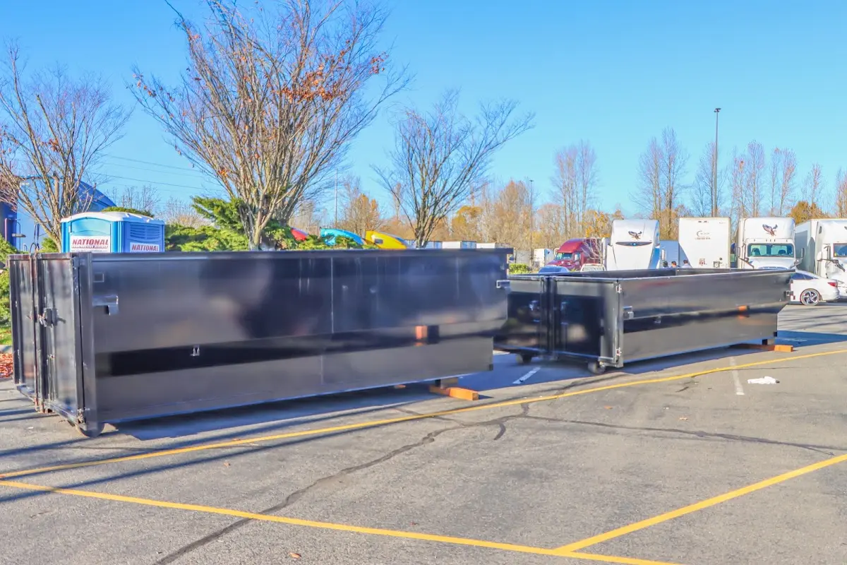 Professional dumpster rental service with roll-off container on residential driveway in Attica